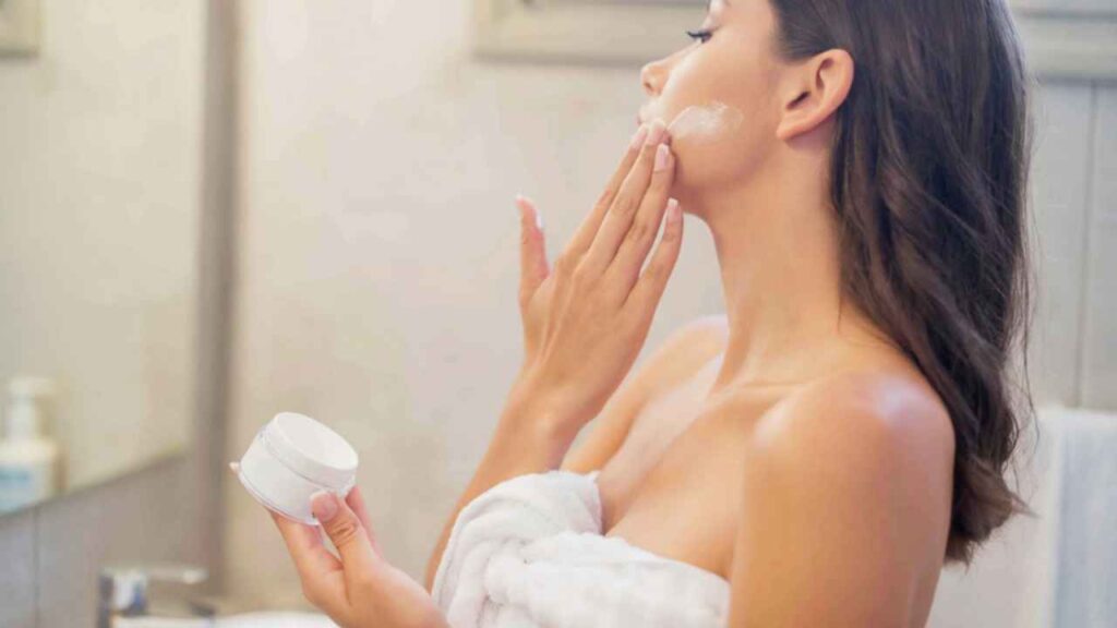 Девушка наносит крем SPF 50 после чистки лица